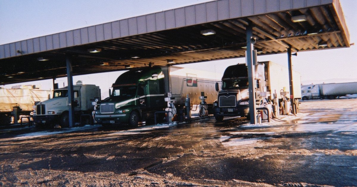 Semi-trucks fueling at a U.S. truck stop, the daily workplace of long-haul drivers
