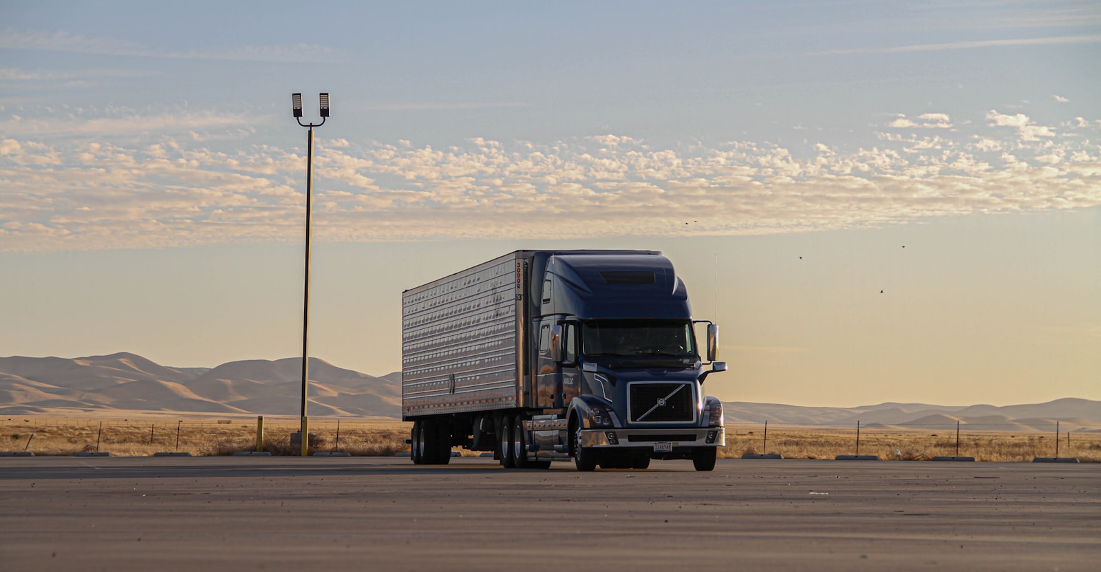 American Volvo VNL conventional semi-truck on a highway at golden hour